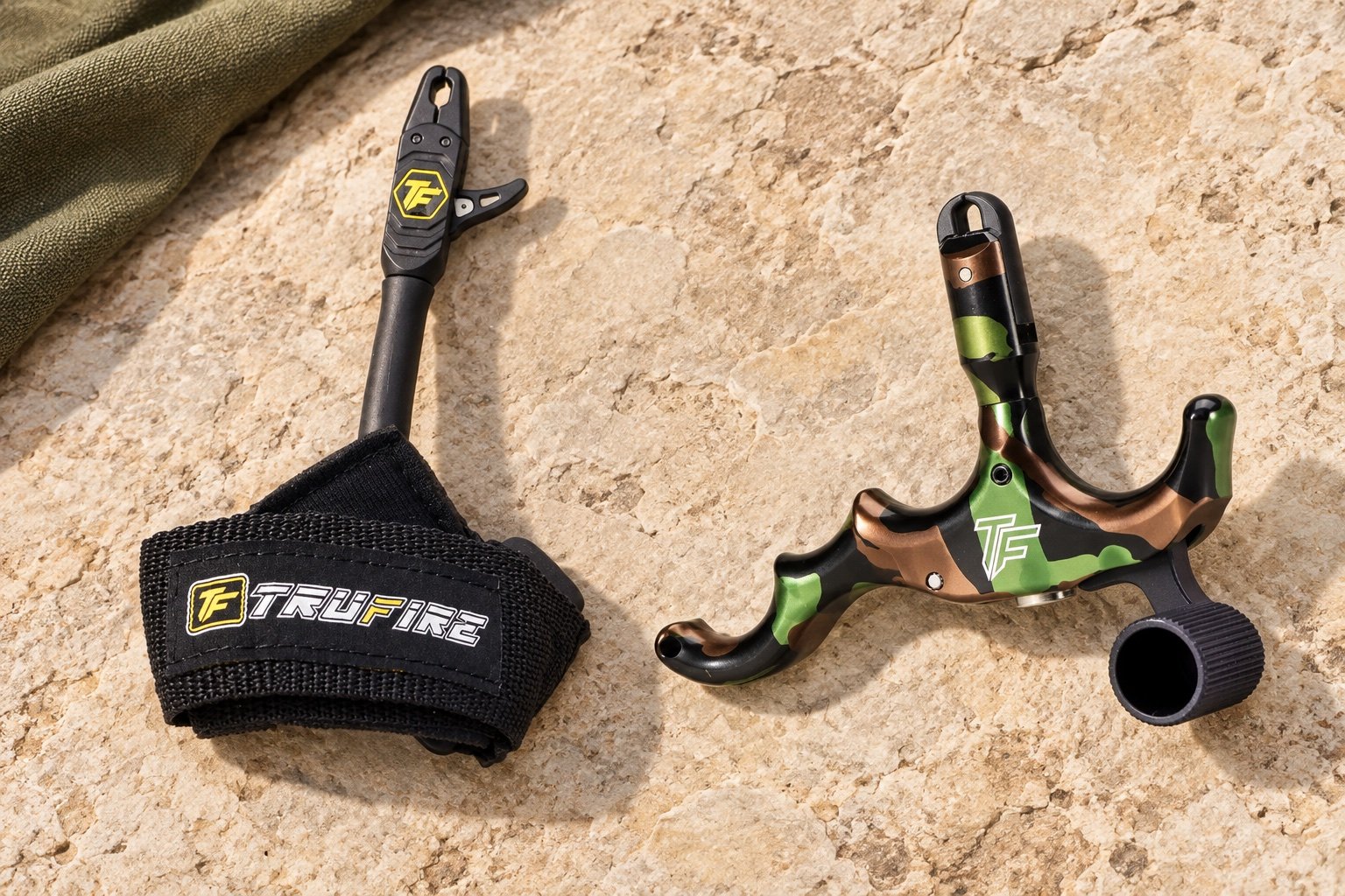 Tru-Fire Patriot wrist strap and Edge handheld releases on pale stone